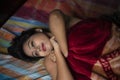 Young Indian brunette woman in sleeping wear lying on a bed Royalty Free Stock Photo