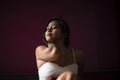 Young Indian brunette woman in sleeping wear sitting on a bed Royalty Free Stock Photo