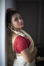 Portrait of an young and attractive Indian woman in white traditional wear for the celebration of Onam/Pongal Royalty Free Stock Photo