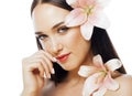 Young attractive lady close up with hands on face isolated flower lily brunette spa nude makeup Royalty Free Stock Photo