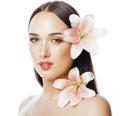 Young attractive lady close up with hands on face isolated flower lily brunette spa nude makeup Royalty Free Stock Photo