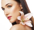 Young attractive lady close up with hands on face isolated flower lily brunette spa nude makeup Royalty Free Stock Photo