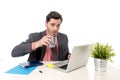 Young attractive Latin businessman working at office computer desk drinking cup of coffee Royalty Free Stock Photo