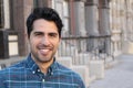 Young and attractive latino male smiling in the city