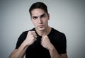 Young attractive man with an angry face in boxing stance ready to fight