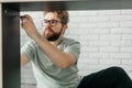 Young attractive man assembles furniture - handwerker and interior objects concept Royalty Free Stock Photo