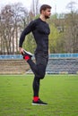 Young attractive man athlete warming up at the stadium