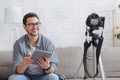 Young attractive man blogger looking at camera and talking on video shooting with devise Royalty Free Stock Photo