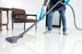 Young attractive man is cleaning vacuum commercial cleaning equipment on floor at home helping wife Royalty Free Stock Photo