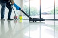 Young attractive man is cleaning vacuum commercial cleaning equipment on floor at home helping wife Royalty Free Stock Photo