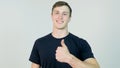 Young attractive man dressed in black t-shirt standing over white background looking at camera and showing thumb up Royalty Free Stock Photo