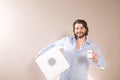 Young attractive man  holding white portable bluetooth speaker on gray background Royalty Free Stock Photo