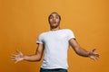 The young attractive man looking suprised isolated on orange