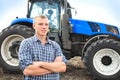 Young attractive man near a tractor. Concept of agriculture. Royalty Free Stock Photo