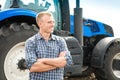 Young attractive man near a tractor. Concept of agriculture Royalty Free Stock Photo