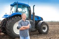 Young attractive man near a tractor. Concept of agriculture Royalty Free Stock Photo