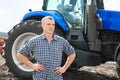 Young attractive man near a tractor. Concept of agriculture. Royalty Free Stock Photo