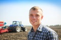 Young attractive man near a tractor. Concept of agriculture. Royalty Free Stock Photo