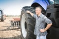 Young attractive man near a tractor. Concept of agriculture. Royalty Free Stock Photo