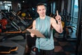 young attractive man personal trainer planning workout with clipboard in gym Royalty Free Stock Photo