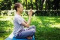 A young attractive man practices yoga in nature and meditates with his eyes closed in the lotus positio Royalty Free Stock Photo