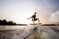 Young attractive man riding on the wakeboard on the background o Royalty Free Stock Photo