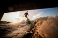 Young attractive man riding on the wakeboard under the bridge Royalty Free Stock Photo