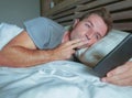 Young attractive man smiling happy lying on bed at night using social media app on mobile phone having video call sending kiss int Royalty Free Stock Photo