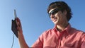 Young attractive man in sunglasses with headphones and mobile phone listen to music while traveling on cruise ship into Royalty Free Stock Photo