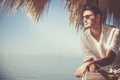 Young attractive man with sunglasses looking out over the sea during the summer. He looking forward, dressed in a white shirt and Royalty Free Stock Photo