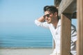 Young attractive man with sunglasses looking out over the sea during the summer. Royalty Free Stock Photo