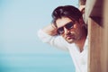 Young attractive man with sunglasses looking out over the sea during the summer. Royalty Free Stock Photo