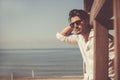 Young attractive man with sunglasses looking out over the sea during the summer. Royalty Free Stock Photo