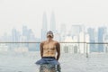 Young attractive man at the swimming pool in roof at skyscraper. Royalty Free Stock Photo