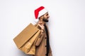 Young attractive man wearing Santa hat holding and pointing red shopping bag in christmas consumerism , December sale, buying xmas Royalty Free Stock Photo