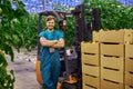 Young attractive man working on electric forklift in greenhouse Royalty Free Stock Photo