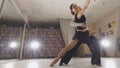 Young attractive man and woman dancing Latin American dance in costumes in the Studio, focus on feet, view from the