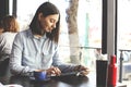 Happy young woman drinking cappuccino, latte, macchiato, tea, using tablet computer and talking on the phone in a coffee shop / ba Royalty Free Stock Photo