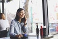 Happy young woman drinking cappuccino, latte, macchiato, tea, using tablet computer and talking on the phone in a coffee shop / ba Royalty Free Stock Photo