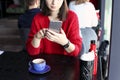 Happy young woman drinking cappuccino, latte, macchiato, tea, using tablet computer and talking on the phone in a coffee shop / ba Royalty Free Stock Photo