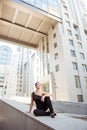 Young attractive minded ballerina sitting on the balusters