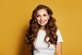 Young attractive model woman wearing white t-shirt on yellow background. Natural makeup, brown hair, cute smile