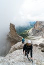 Young attractive mountain climbers on very exposed Via Ferrata in the Dolomites of Italy