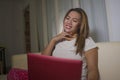 Young attractive and natural latin woman in pajamas pants relaxed on couch networking using laptop computer shopping online Royalty Free Stock Photo