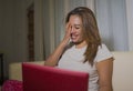 Young attractive and natural latin woman in pajamas pants relaxed on couch networking using laptop computer shopping online Royalty Free Stock Photo