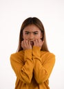 Young attractive nervous scared asian girl bitting her nails in studio