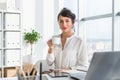 Young attractive office worker drinking cup of tea, having coffee break in the morning, getting ready for work day. Royalty Free Stock Photo