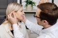 A young attractive otolaryngologist doctor gives a consultation to a female patient. A doctor explains how to wear a hearing aid Royalty Free Stock Photo