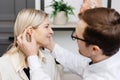 A young attractive otolaryngologist doctor gives a consultation to a female patient. A doctor explains how to wear a hearing aid Royalty Free Stock Photo