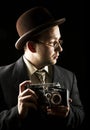 Young and attractive photographer in vintage suit and with retro photo camera. Royalty Free Stock Photo